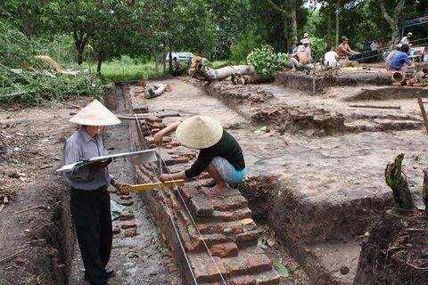Archeologists measure the area of the old foundation (Photo: VNA)